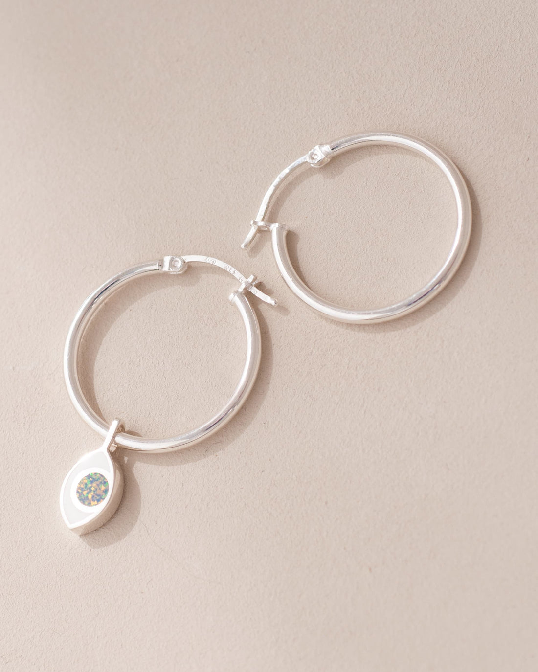 silver hoops with silver eye charm inlaid with opal